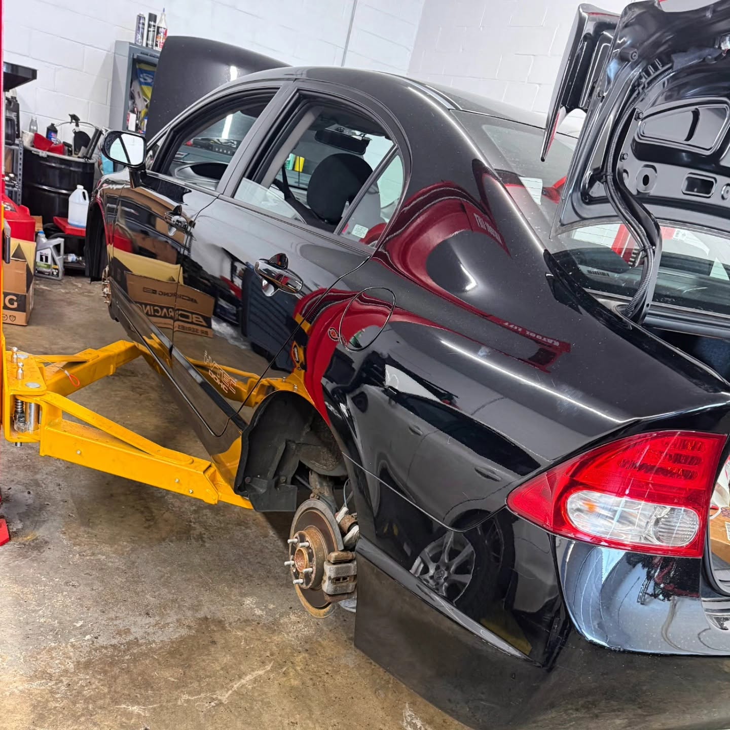 Performance car on a lift with its rear brake and suspension exposed