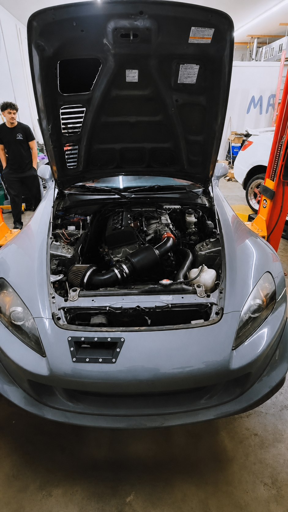 Silver Honda S2000 with an upgraded intake in its open engine bay