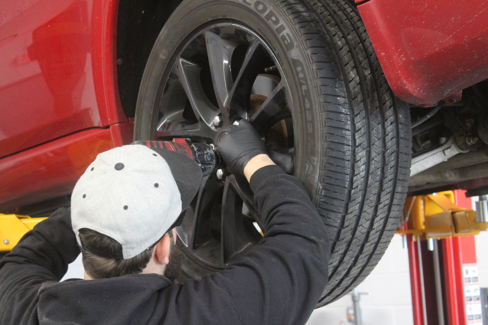 Mr. Honditas technician installing a wheel on a raised vehicle in Toms River, NJ